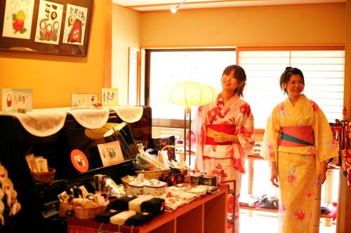 two women in kimonos standing in a room at 城崎温泉 旅館 つばき乃 - Kinosaki Onsen Ryokan Tsubakino in Toyooka