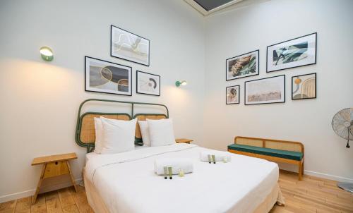 - une chambre avec un grand lit blanc et des photos sur le mur dans l'établissement CIA - Notre Dame spacious Home, à Paris
