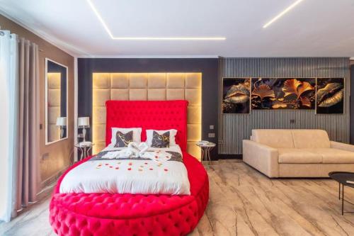 a bedroom with a large red bed and a couch at Ruby's - By Solea Holiday Homes in St Julian's