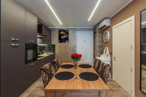 a kitchen with a wooden table and chairs at Ruby's - By Solea Holiday Homes in St Julian's