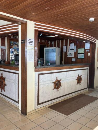 a lobby with a counter with a bar in a building at Hotel Veleiro in Florianópolis