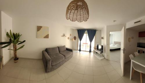 a living room with a couch and a table at Hôtel Montaigne & Spa - Cannes Centre in Cannes
