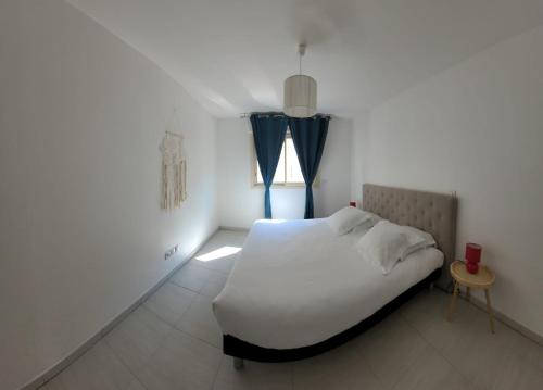 a bedroom with a white bed and a window at Hôtel Montaigne & Spa - Cannes Centre in Cannes