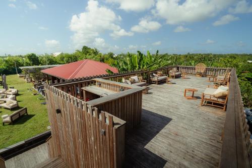 a deck with chairs and tables on top of a resort at Ecolodge Anacardier -Bungalow Deluxe 1 in Saint-François