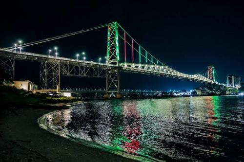 a bridge over the water at night with lights at Hotel Veleiro in Florianópolis