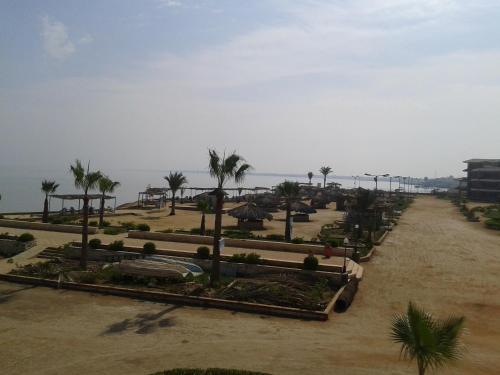 a view of a resort with palm trees and the ocean at Fanara Apartments Armed Forces in Fayed