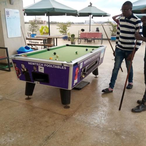 a man playing pool with a pool table at Kimsy Signature Homes in Kiambu