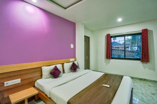 a bedroom with a large bed with a purple wall at Antonios Calangute beach in Calangute