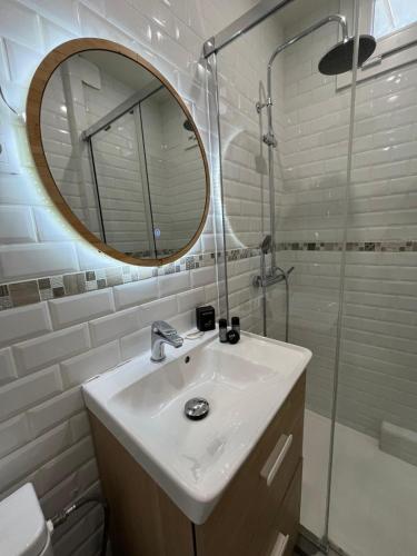 une salle de bain avec un lavabo, un miroir et une douche dans l'établissement Dalikyda - Le Clovis - Central, au Havre
