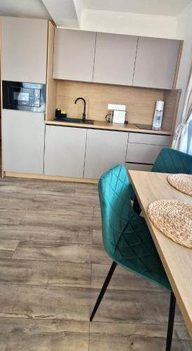 a kitchen with a wooden table and a green chair at Grand Apartman - 5 Star Luxury Podhajska Apartman in Podhájska
