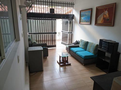 salon z niebieską kanapą i telewizorem w obiekcie Habitacion 201 Casa Luz El Rodadero w mieście Gaira