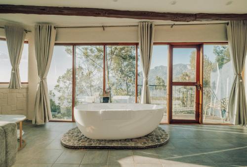 a large bath tub in a room with windows at Java Boutique Hotel in Lushoto