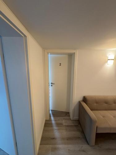a room with a couch and a hallway with a door at NEU renoviertes Apartment 3 Zimmer 4 Boxspringbetten moderne Küche und vieles mehr in Löhne