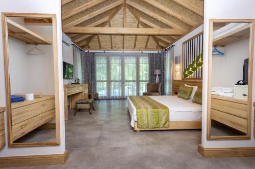 a bedroom with a bed and a large window at Gizli Cennet Villages Hotel in Fethiye