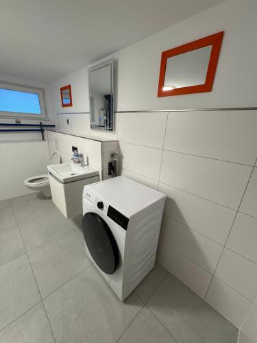 a bathroom with a washing machine and a toilet at NEU renoviertes Apartment 3 Zimmer 4 Boxspringbetten moderne Küche und vieles mehr in Löhne