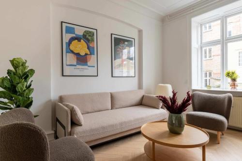a living room with a couch and chairs and a table at Stylish and Bright 2 Bedroom in CPH N in Copenhagen
