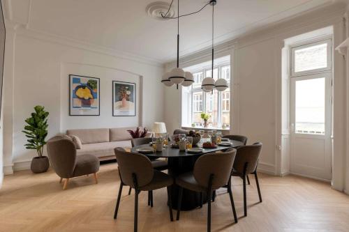 a living room with a table and chairs and a couch at Stylish and Bright 2 Bedroom in CPH N in Copenhagen