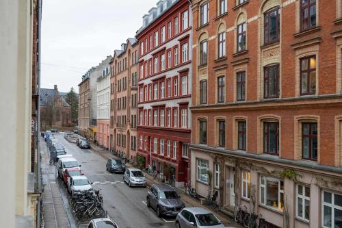 a city street with cars parked next to tall buildings at Stylish and Bright 2 Bedroom in CPH N in Copenhagen