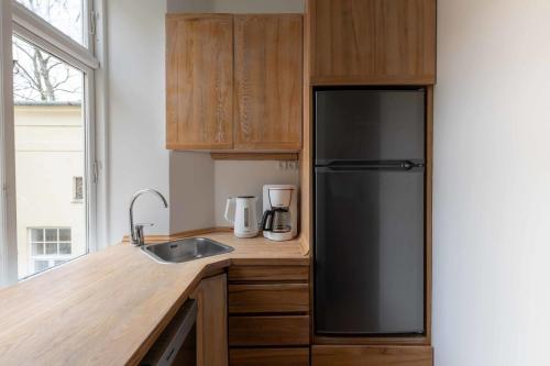 a kitchen with a black refrigerator and a sink at Stylish and Bright 2 Bedroom in CPH N in Copenhagen