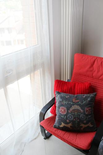 a red chair with a pillow sitting next to a window at Apartment in Siena with private parking in Siena