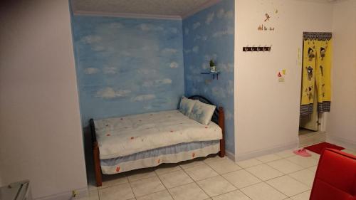 Un dormitorio con una pared azul con una cama. en Wujie My Home en Wujie