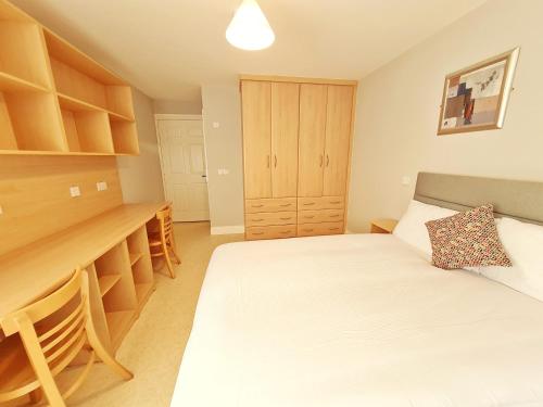 a small bedroom with a bed and a desk at Ceann Boirne Apartments in Galway