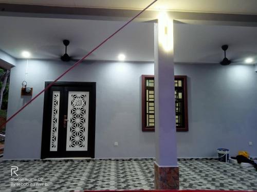 a room with a white wall with a door at D'Intan Villa Gerik in Gerik