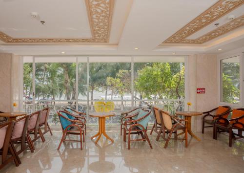 une salle à manger avec tables, chaises et fenêtres dans l'établissement Nang Vang Hotel Nha Trang, à Nha Trang