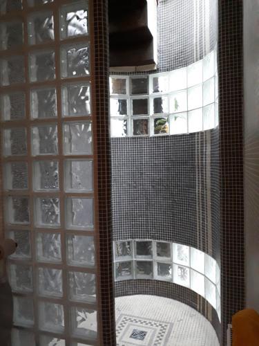 - une douche vitrée dans une chambre avec fenêtre dans l'établissement Le nichoir aux oiseaux, à Paris