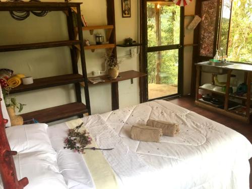 a bedroom with a large bed with white sheets at La Senda del Barcino in Cali