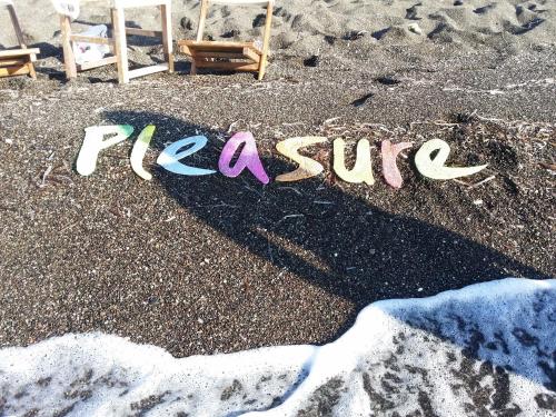 a sign written in the sand on a beach at Hotel Pleasure Black Beach Perissa Santorini in Perissa