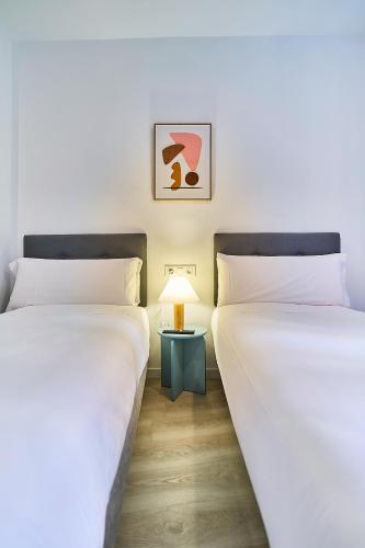 two beds sitting next to each other in a room at Hotel Gran Vía by gaiarooms in Salamanca