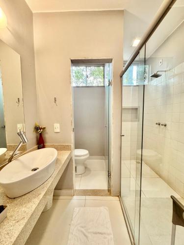 a bathroom with a sink and a toilet and a shower at Pousada Casa das Flores in Sao Jorge