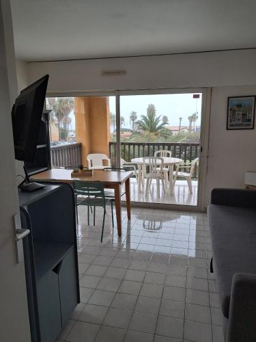 - un salon avec une table et une vue sur un patio dans l'établissement Proche plage à Gassin 35, à Gassin