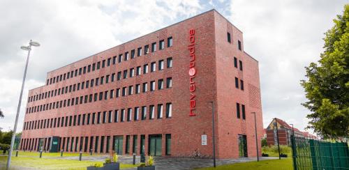 a brick building with a red sign on it at havenstudios Bremerhaven in Bremerhaven