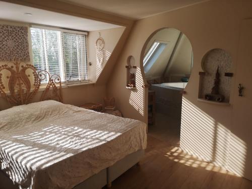 a bedroom with a bed and a mirror and a sink at Modern Cozy Asian Style bedroom with Kingsize Spa bath in Westbeemster