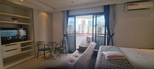 a bedroom with a bed and a large window with a view at Bienal Suites Ibirapuera c/ Sacada - UH 1207 in São Paulo