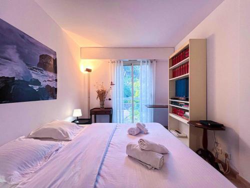 a bedroom with a large bed with towels on it at Terrasse Vue Mer - A quelques minutes de Cannes in Le Cannet