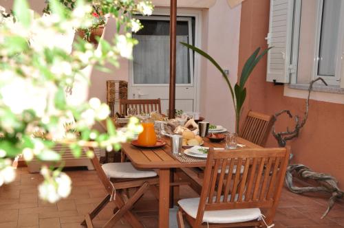 Stella di Mare في لا ماداّلينا: طاولة وكراسي خشبية عليها طعام