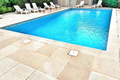 - une piscine avec des chaises longues et des chaises dans l'établissement Terrasse Vue Mer - A quelques minutes de Cannes, au Cannet
