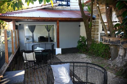 a patio with chairs and a table and a tree at Hotel Los Ángeles in Mar del Plata