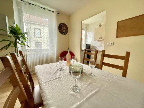 une table de salle à manger avec des verres à vin dessus dans l'établissement Top T3 super cosy frontière suisse, à Delle