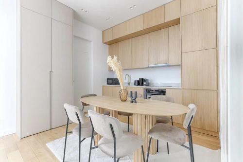 une salle à manger avec une table et des chaises en bois dans l'établissement Montparnasse - Modern & renovated 3BD for 8 guests, à Paris