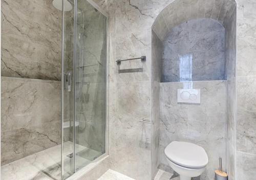 une salle de bain avec toilettes et douche en verre dans l'établissement Montparnasse - Modern & renovated 3BD for 8 guests, à Paris