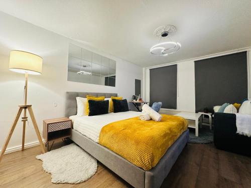 a bedroom with a bed with a yellow blanket at Opulent Retreat in London