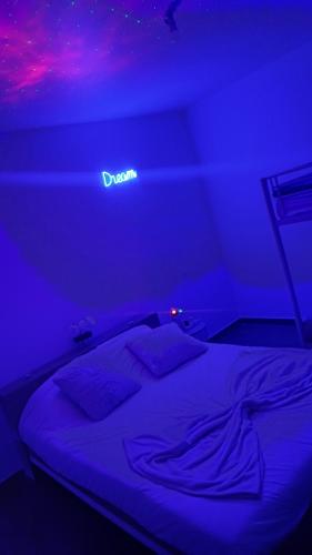 a bed in a room with a purple lighting at Villa piscine jacuzzi Montpellier in Juvignac