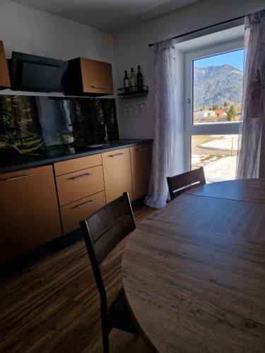 una cucina con un tavolo e una grande finestra di Ferienmaisonette Purpurbuche a Reutte