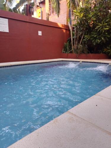a swimming pool with blue water in front of a building at ARAMI HOTEL & LODGE in Puerto Iguazú