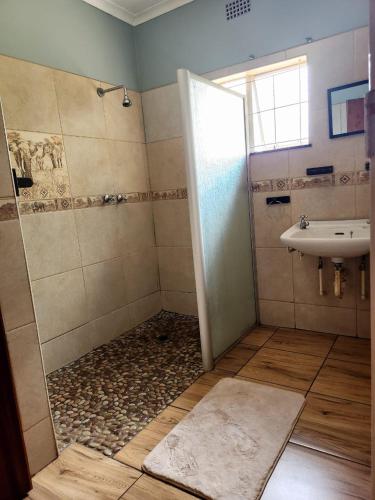 a bathroom with a shower and a sink at Majestic Guest House in Mokopane