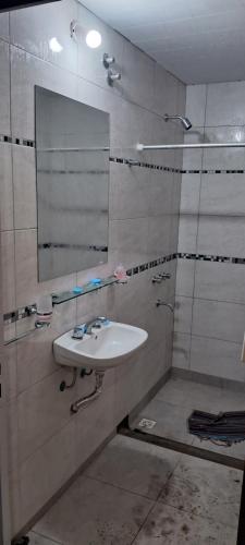 un baño con lavabo y espejo en Excelente Ubicación con Cochera Privada, en Ciudad Evita